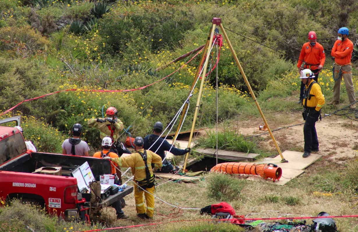 Members of a rescue team work at a site where three bodies were found, in La Bocana