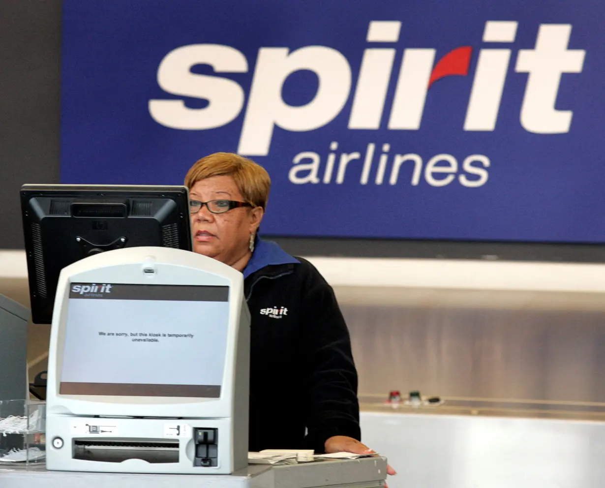 FILE PHOTO: A Spirit Airlines ticketing agent stands at the ticket counter after a Spirit Pilots strike was called, cancelling all Spirit flights, at Detroit Metropolitan Airport in Romulus