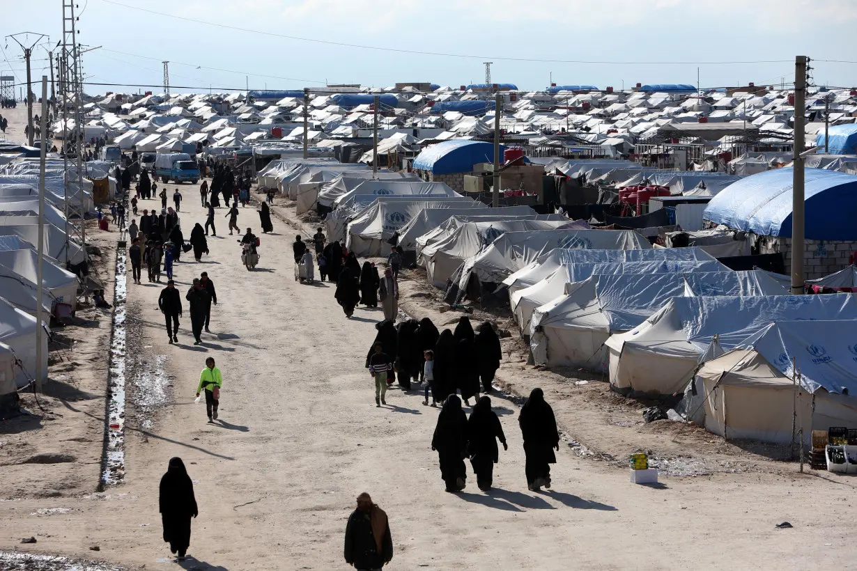 Women walk through al-Hol displacement camp in Hasaka governorate