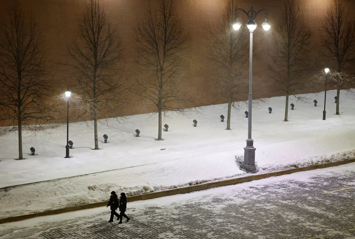 Law enforcement officers walk along the Kremlin wall during New Year's Eve celebrations in Moscow