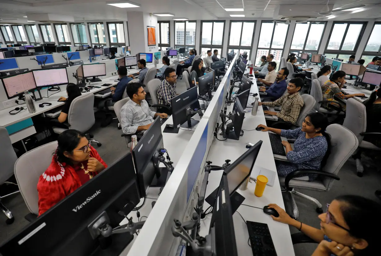 Employees work on their terminals inside the office of Manubhai & Shah LLP in Ahmedabad