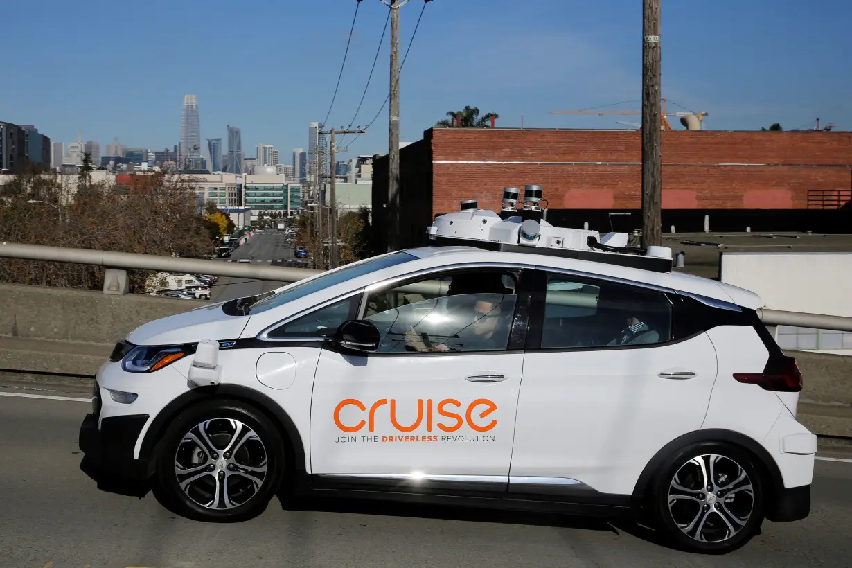 FILE PHOTO: The San Francisco skyline is seen behind a self-driving GM Bolt EV during a media event where Cruise, GMÕs autonomous car unit, showed off its self-driving cars in San Francisco