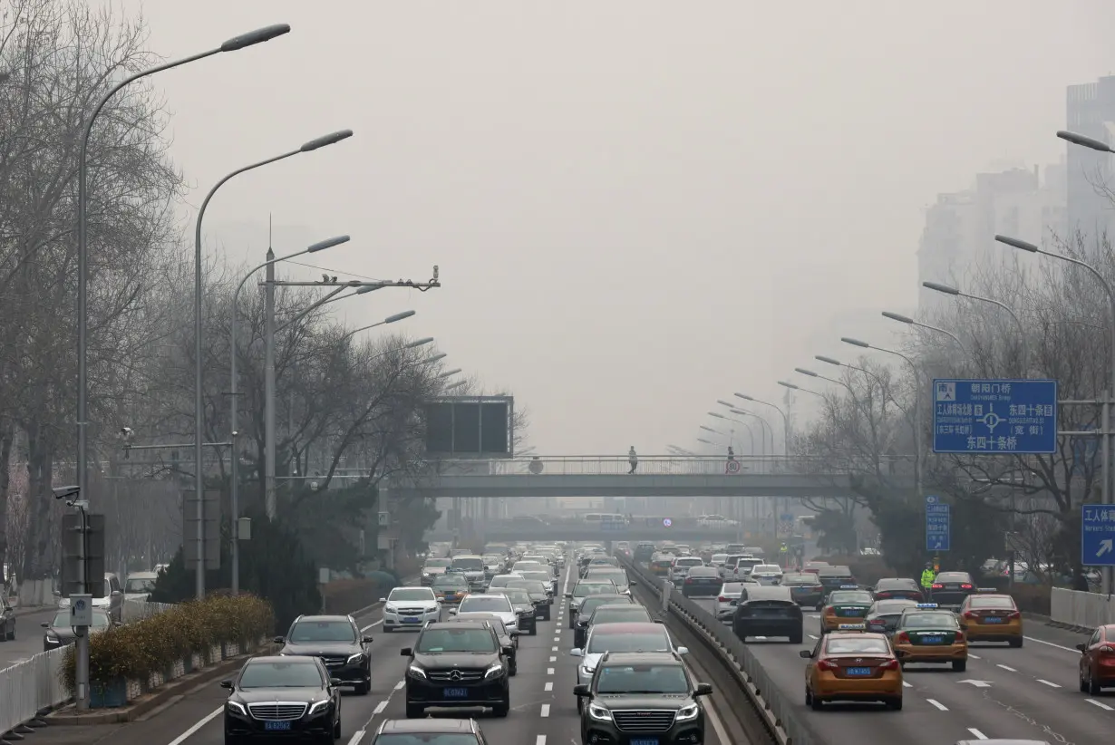 Cars drive in the city centre during a polluted day in Beijing