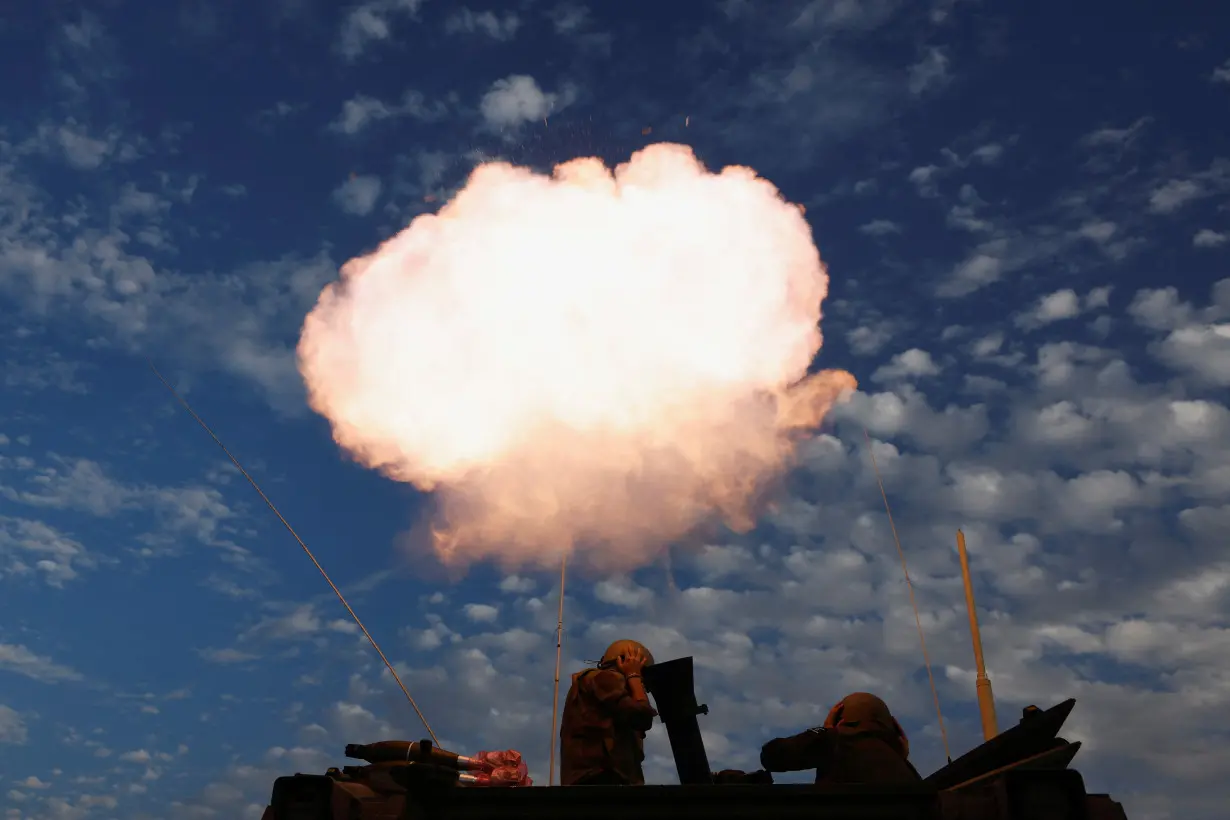 Israeli soldier reacts while firing a mortar as the conflict continues between Israel and Hamas