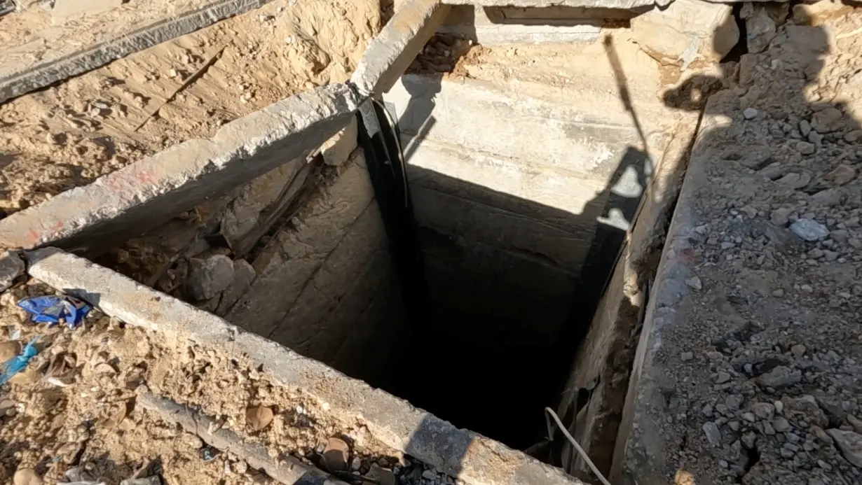 An Israeli soldier shows located Hamas tunnel shaft near the school, during the ongoing ground operation of the Israeli army against Palestinian Islamist group Hamas, in a location given as Beit Lahiya