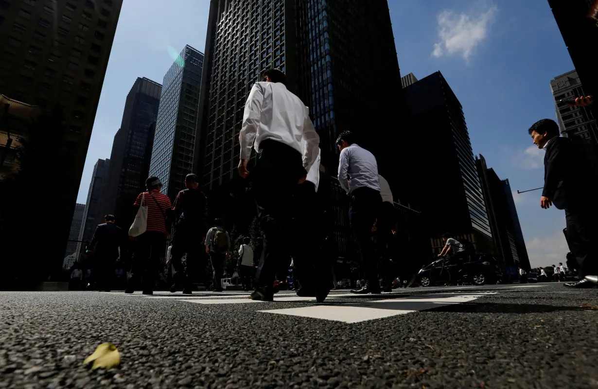 FILE PHOTO: People walk on a crosswalk at a business district in central Tokyo