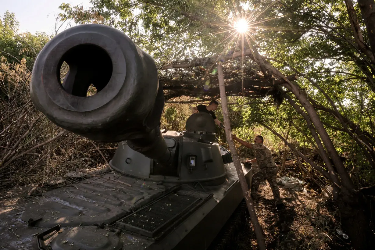 FILE PHOTO: Servicemen prepare a howitzer to fire towards Russian troops at a frontline near the town of Chasiv Yar