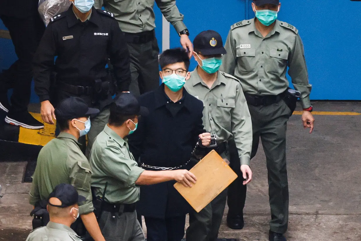 FILE PHOTO: Pro-democracy activist Joshua Wong walks to a prison van to head to court with other activists, over a national security law charge, in Hong Kong