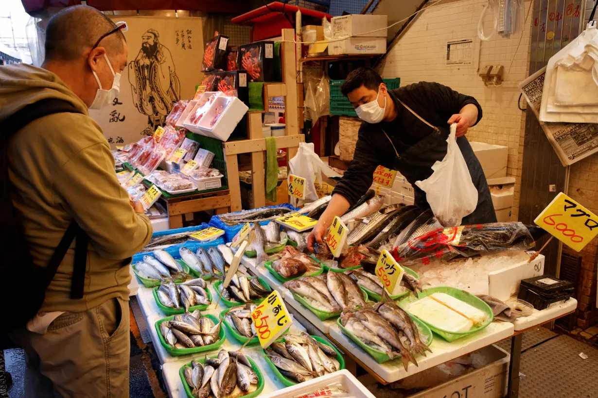 Man buys fish at a market in Tokyo