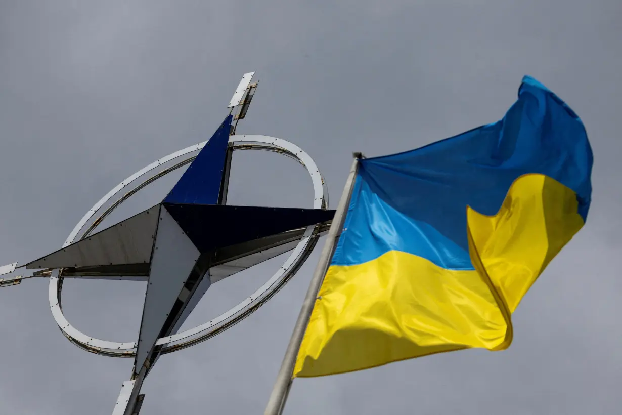 FILE PHOTO: Ukrainian national flag is pictured in front of the NATO emblem in central Kyiv