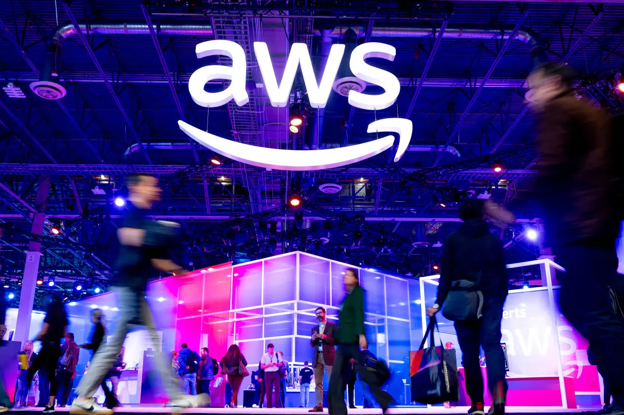 FILE PHOTO: Attendees walk through an expo hall at AWS re:Invent 2023, a conference hosted by Amazon Web Services (AWS), in Las Vegas