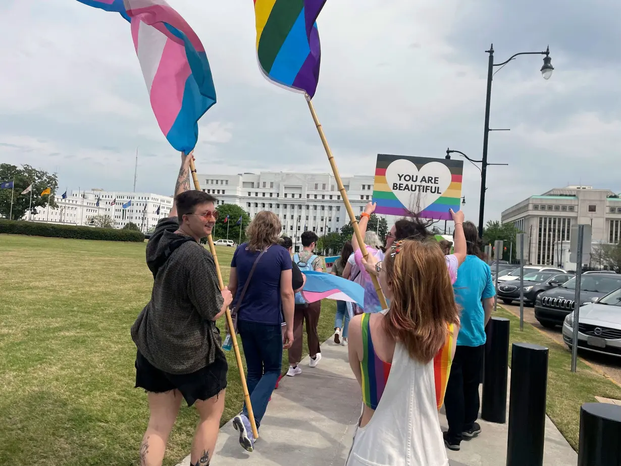 People participate in a rally outside the Alabama Statehouse on International Transgender Day of Visibility in March 2023.