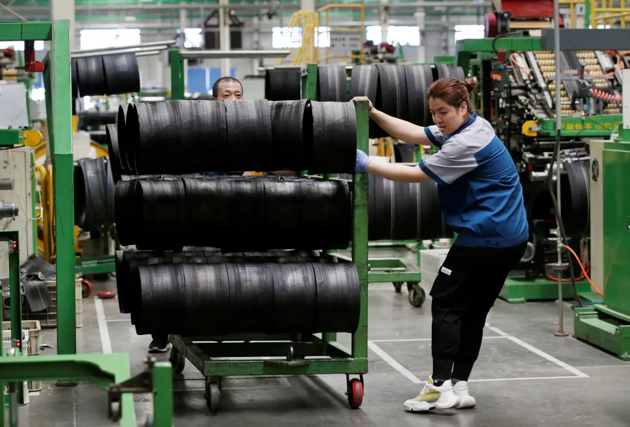 Employees work on the production line of a tyre factory under Tianjin Wanda Tyre Group in Xingtai