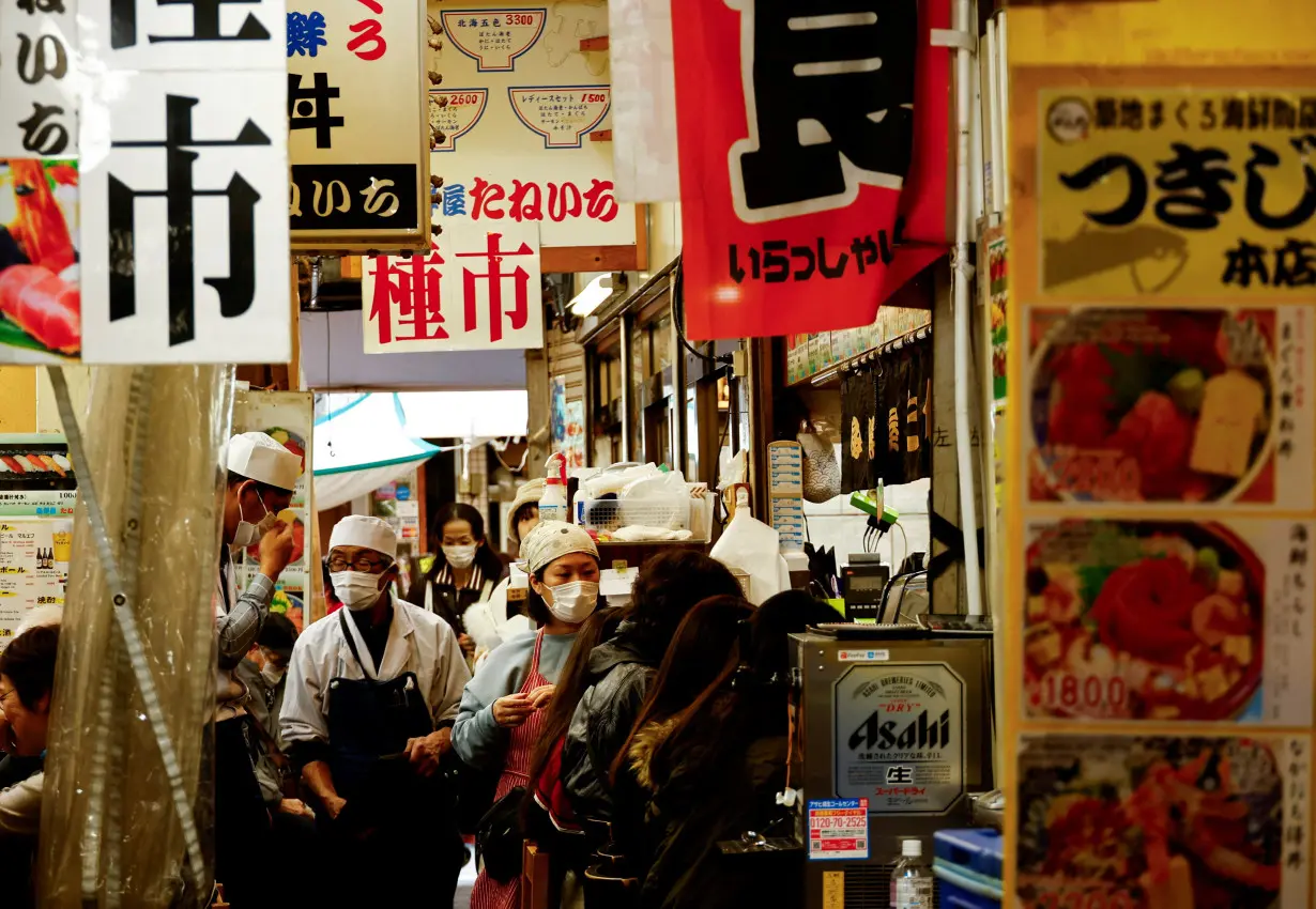 FILE PHOTO: Employees of seafood restaurants work at Tsukiji outer market in Tokyo