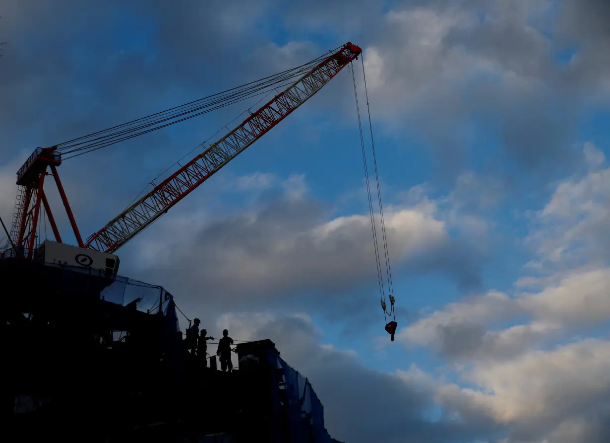 Workers are seen at a construction site at a business district in Tokyo