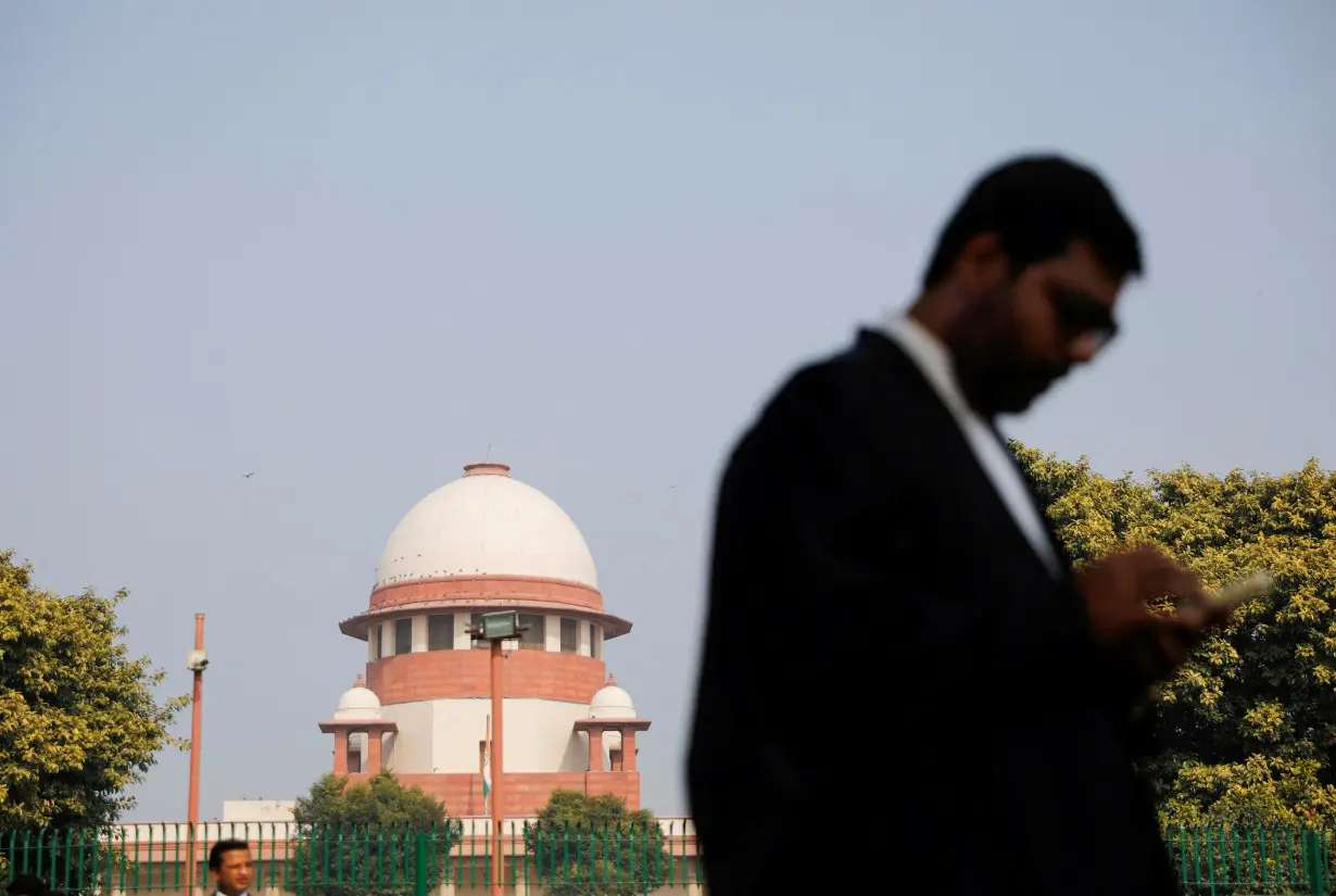 FILE PHOTO: A lawyer looks into his mobile phone in front India's Supreme Court in New Delhi