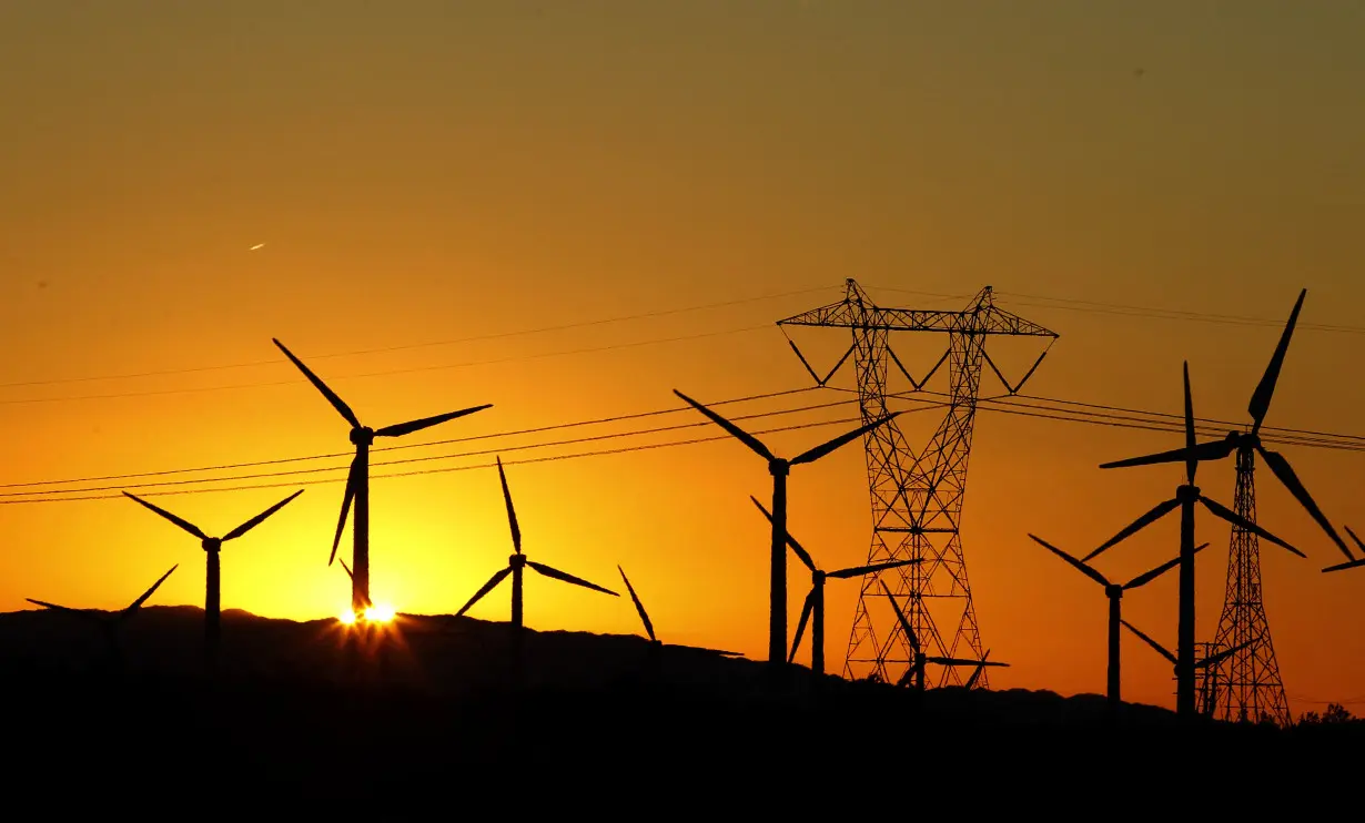 FILE PHOTO: The sun rises behind windmills at a wind farm in Palm Springs