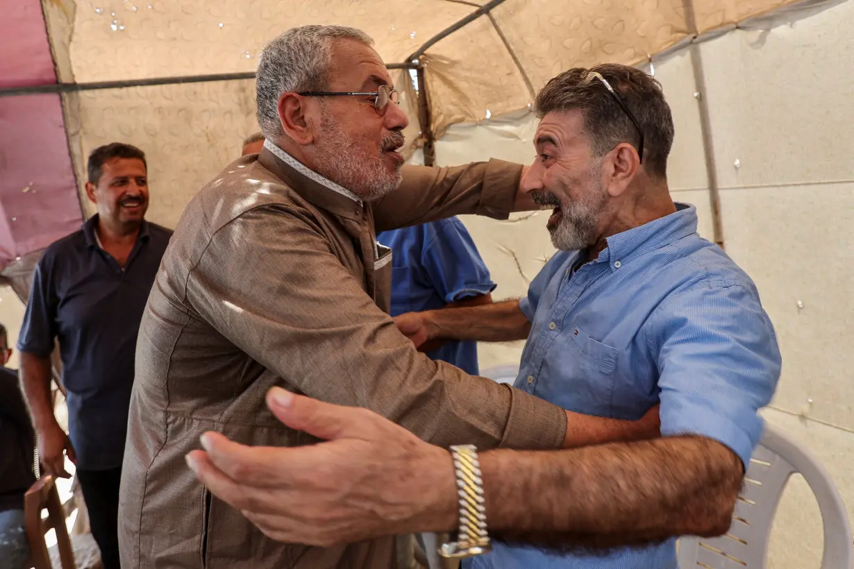 Youssef Mikdad, a former Palestinian prisoner recently released by Israel, is hugged by a man, in Deir Al-Balah in central Gaza Strip