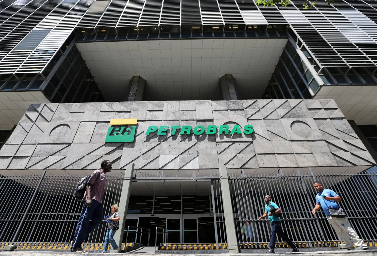 FILE PHOTO: People walk in front of the headquarters of Petroleo Brasileiro S.A. (Petrobas) in Rio de Janeiro