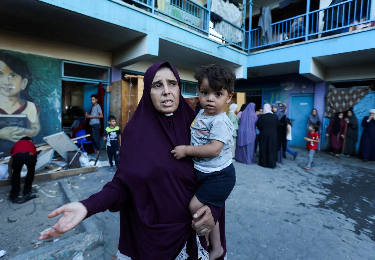 Palestinians react, after an Israeli air strike on a UN school sheltering displaced people, amid the Israel-Hamas conflict, in Nusairat