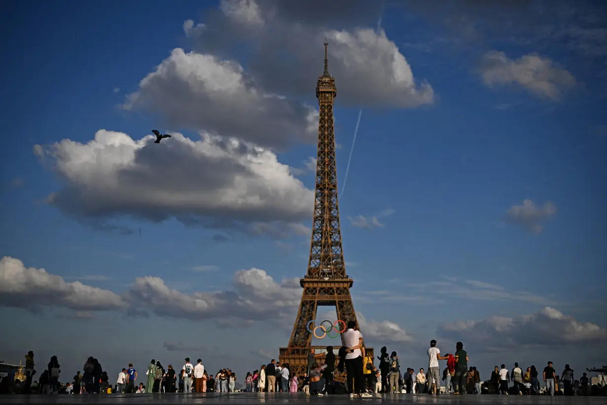 People enjoy the eveneing as the Olympic rings are displayed on the Eiffel Tower in Paris