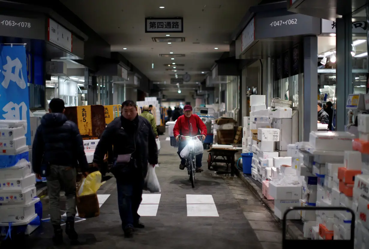 Shoppers and whilesalers walk at Toyosu Fish Market in Tokyo