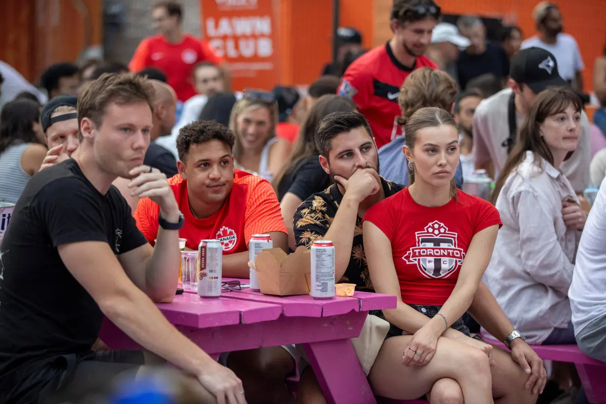 Soccer fans react while watching the televised Copa America semi-final match between Canada and Argentina