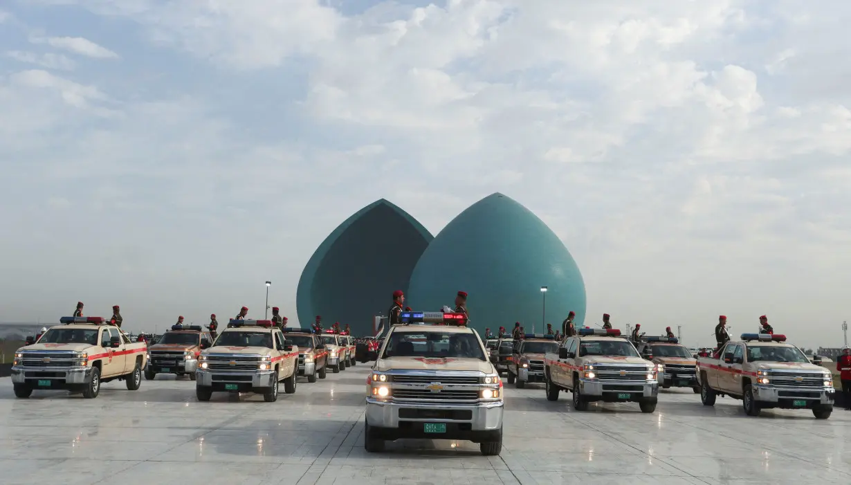 FILE PHOTO: Military vehicles belonging to the Iraqi security forces carry body remains of people from the minority Yazidi during a funeral ceremony in Baghdad