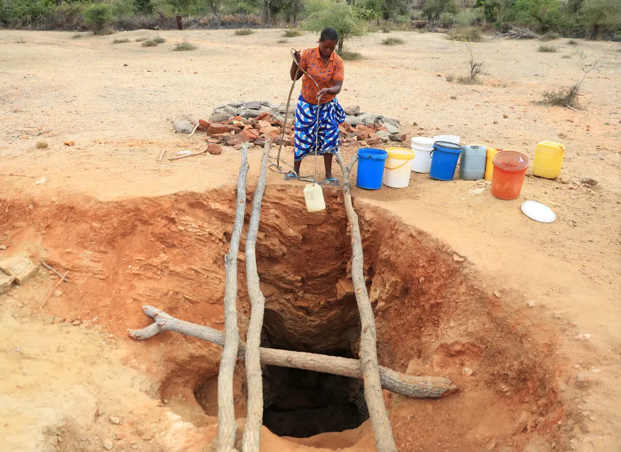 A woman fetches drinking water from an unprotected well, in Kotwa in Mudzi district