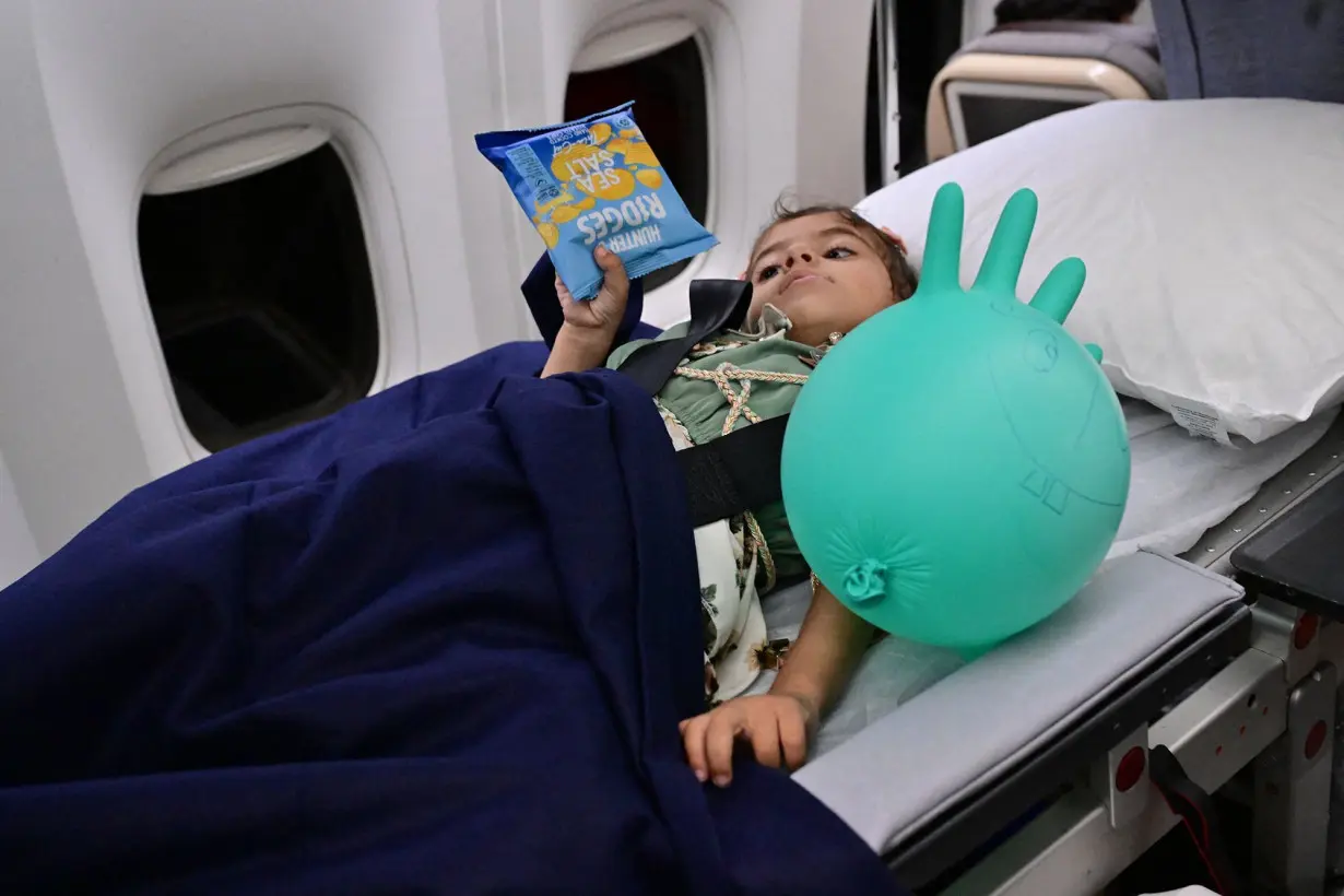 Four-year-old Julia, who was evacuated from the Gaza Strip, lies inside an Emirati aircraft transferring her from Egypt's Arish to receive treatment in the United Arab Emirates, on July 5.