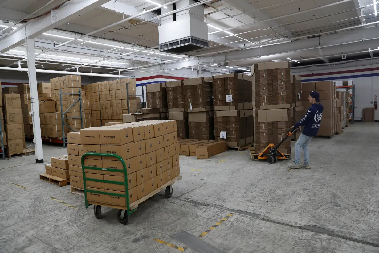 An employee of Defender Safety moves products inside their warehouse in Plainview, New York