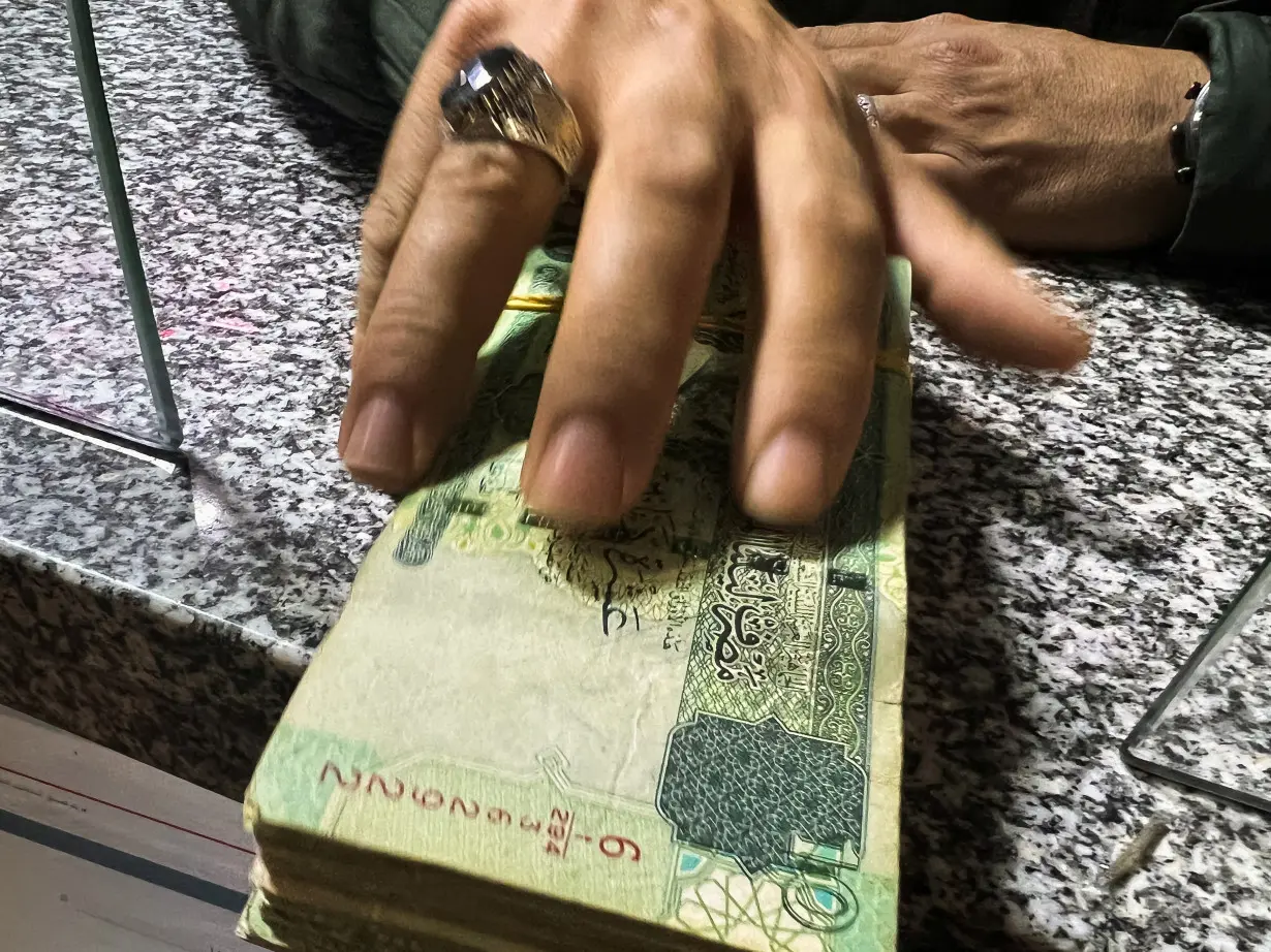 A man receives money from a bank employee in Misrata