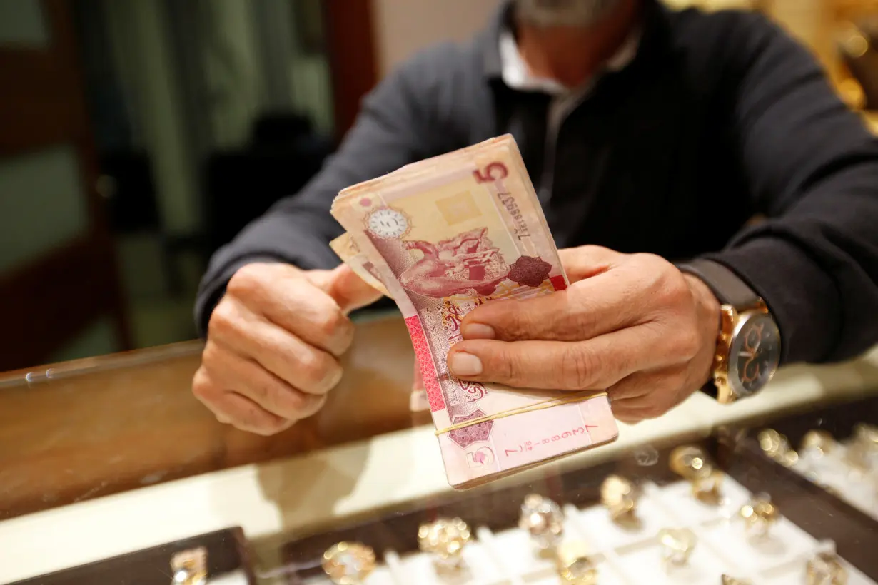 A man counts Libyan dinars at a currency exchange office in Tripoli