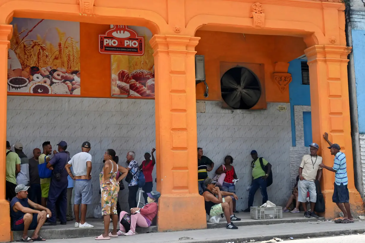 FILE PHOTO: People wait in line to buy bread in downtown Havana, Cuba