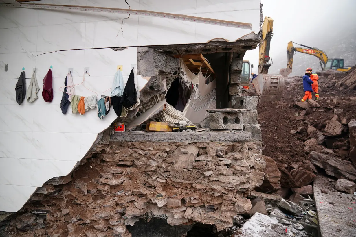 Rescue workers search for survivors near a damaged house after a landslide hit Zhenxiong county in Zhaotong