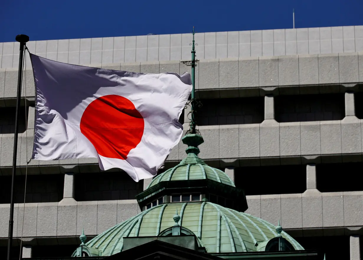 FILE PHOTO: FILE PHOTO: Japanese national flag waves at the Bank of Japan building in Tokyo