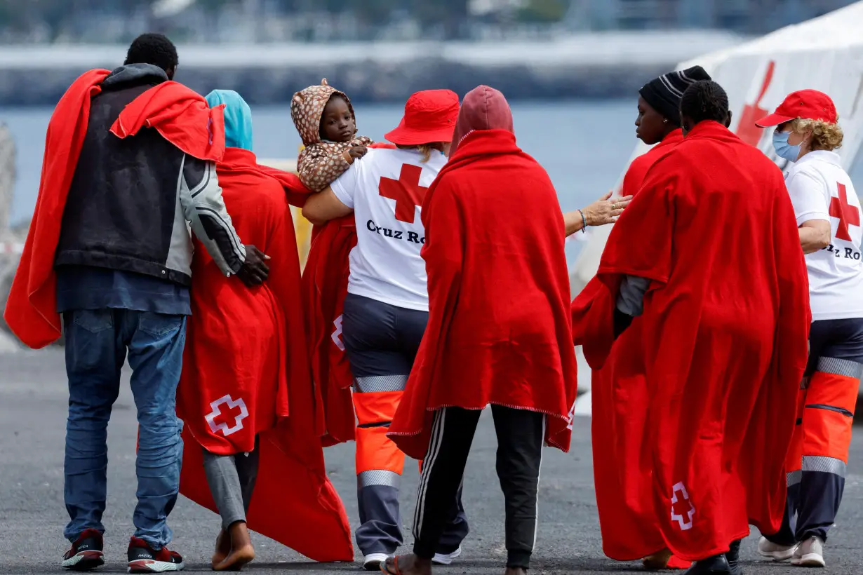 FILE PHOTO: Migrants disembark from a Spanish coast guard vessel at the port of Arguineguin