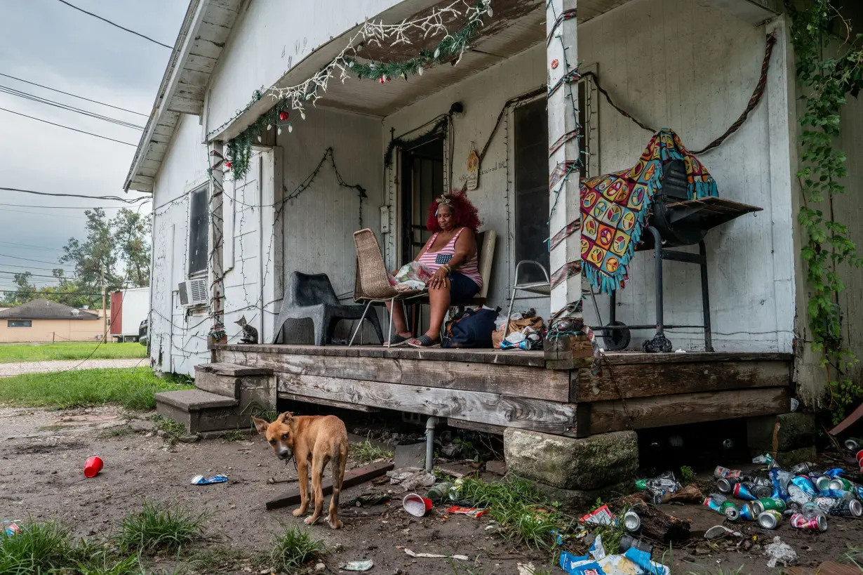 Menifee Lucy sits on her porch for air on Thursday as her Houston home remains without power.