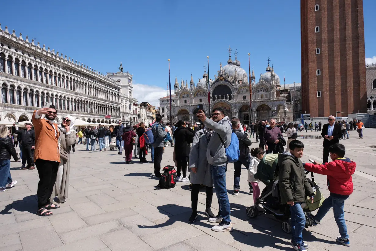 FILE PHOTO: Tourists walk in St Mark's Square on the day Venice municipality introduces a new fee for day trippers