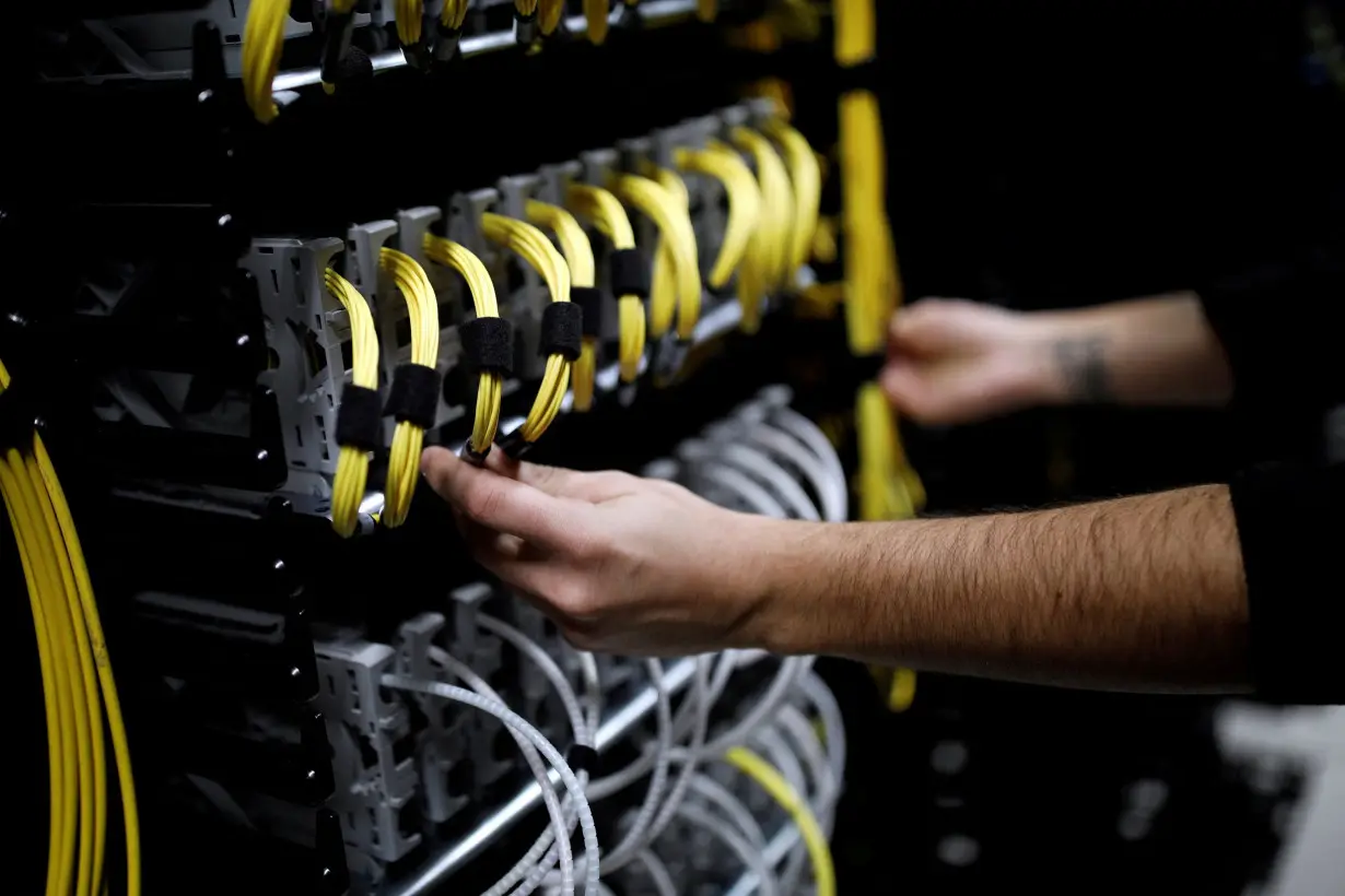 FILE PHOTO: Cables run into the back of a server unit inside the data center of Equinix in Pantin, near Paris