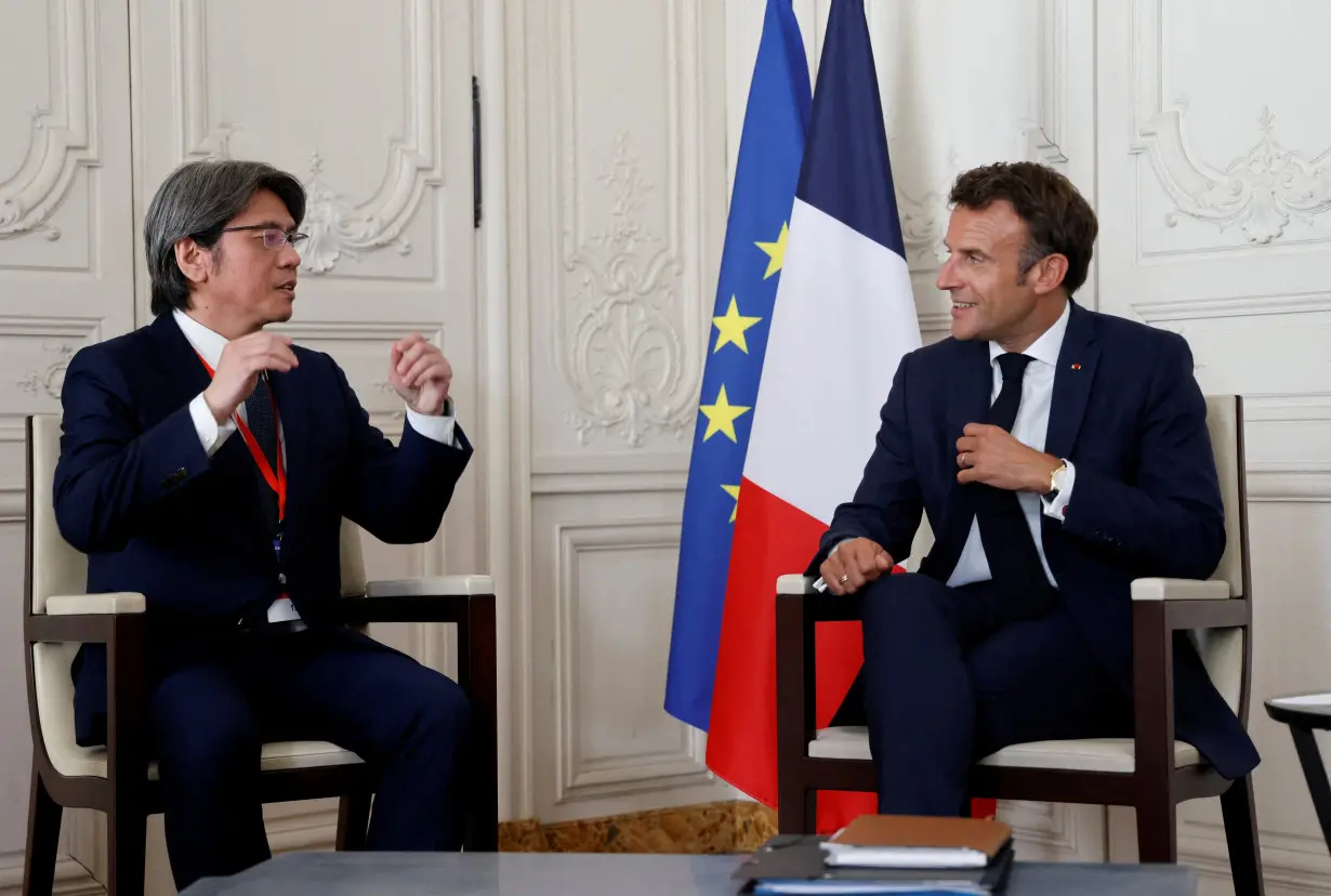 FILE PHOTO: France's President Emmanuel Macron speaks with ProLogium's CEO Vincent Yang
