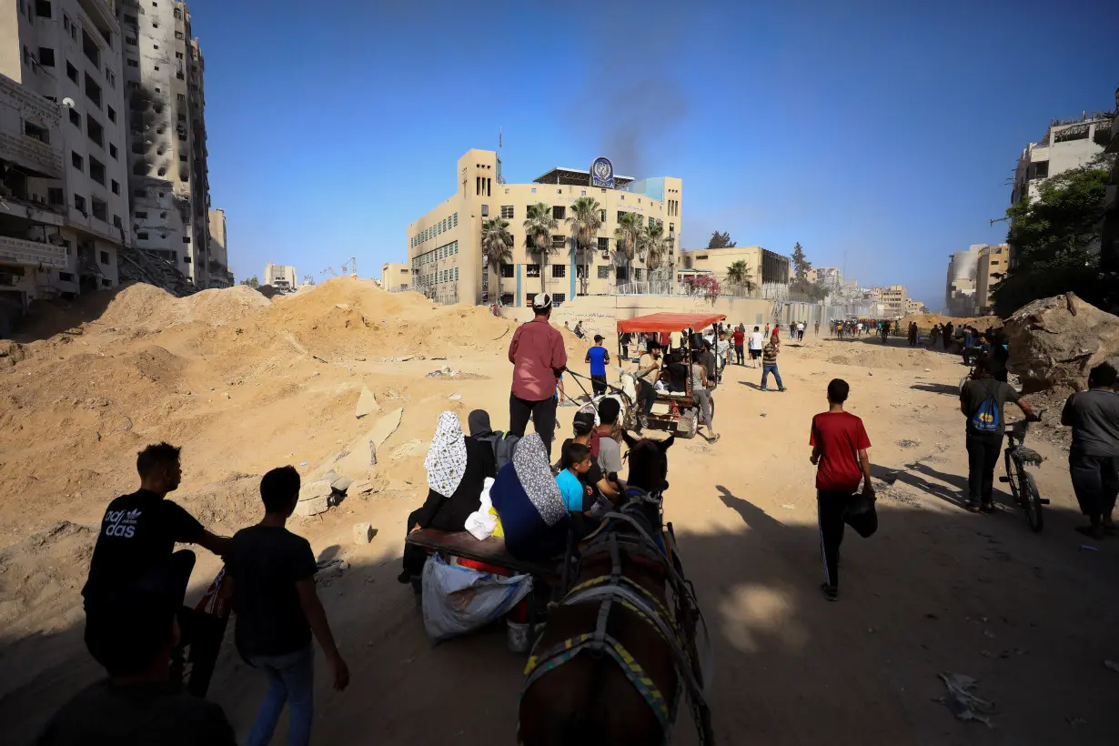 Palestinians gather to inspect the damages at the headquarters of UNRWA in Gaza City