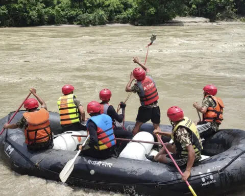Rescuers recover first body from 2 buses that were hit by landslide and fell into a river in Nepal