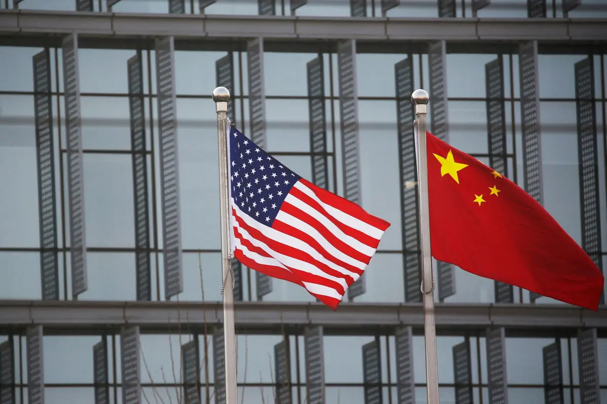 FILE PHOTO: Chinese and U.S. flags flutter outside the building of an American company in Beijing