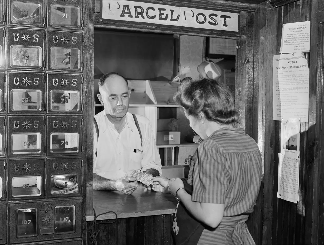 Woman buying stamps in Siren, Wisconsin, in 1941.