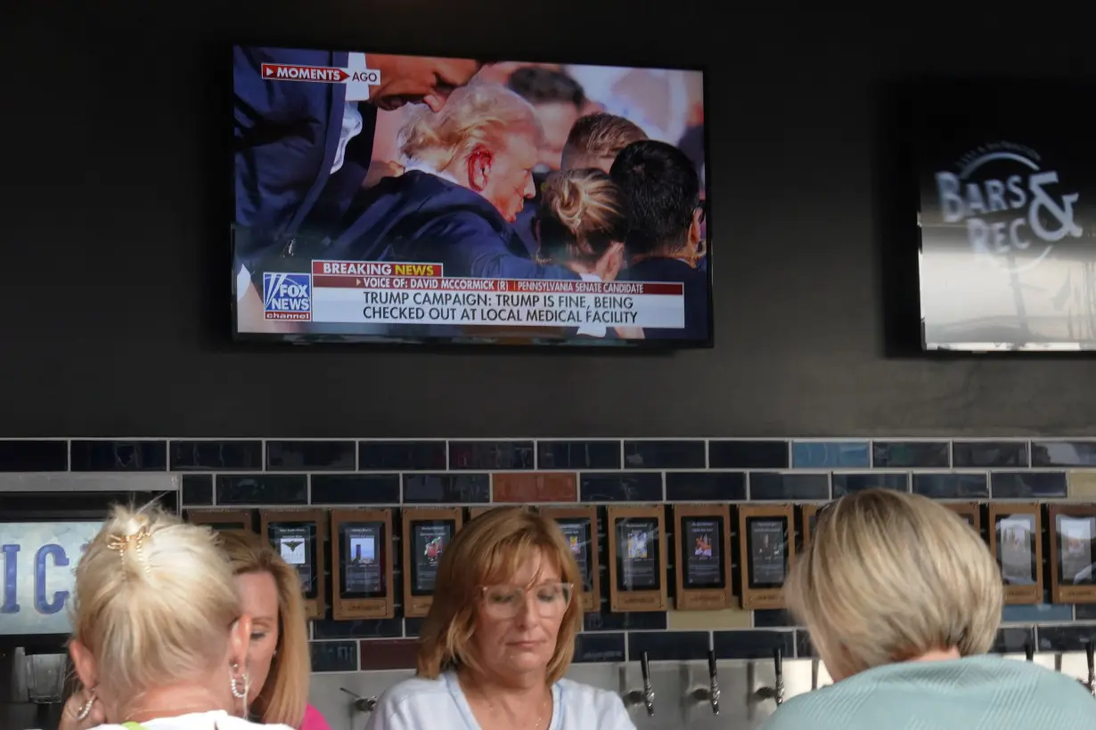 Delegates look at news reports outside the Republican National Convention are underway in Milwaukee