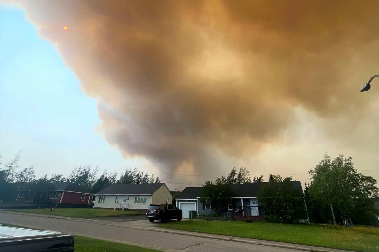 Smoke from an encroaching wildfire is seen over homes after an evacuation was ordered in the eastern Canadian community of Labrador City