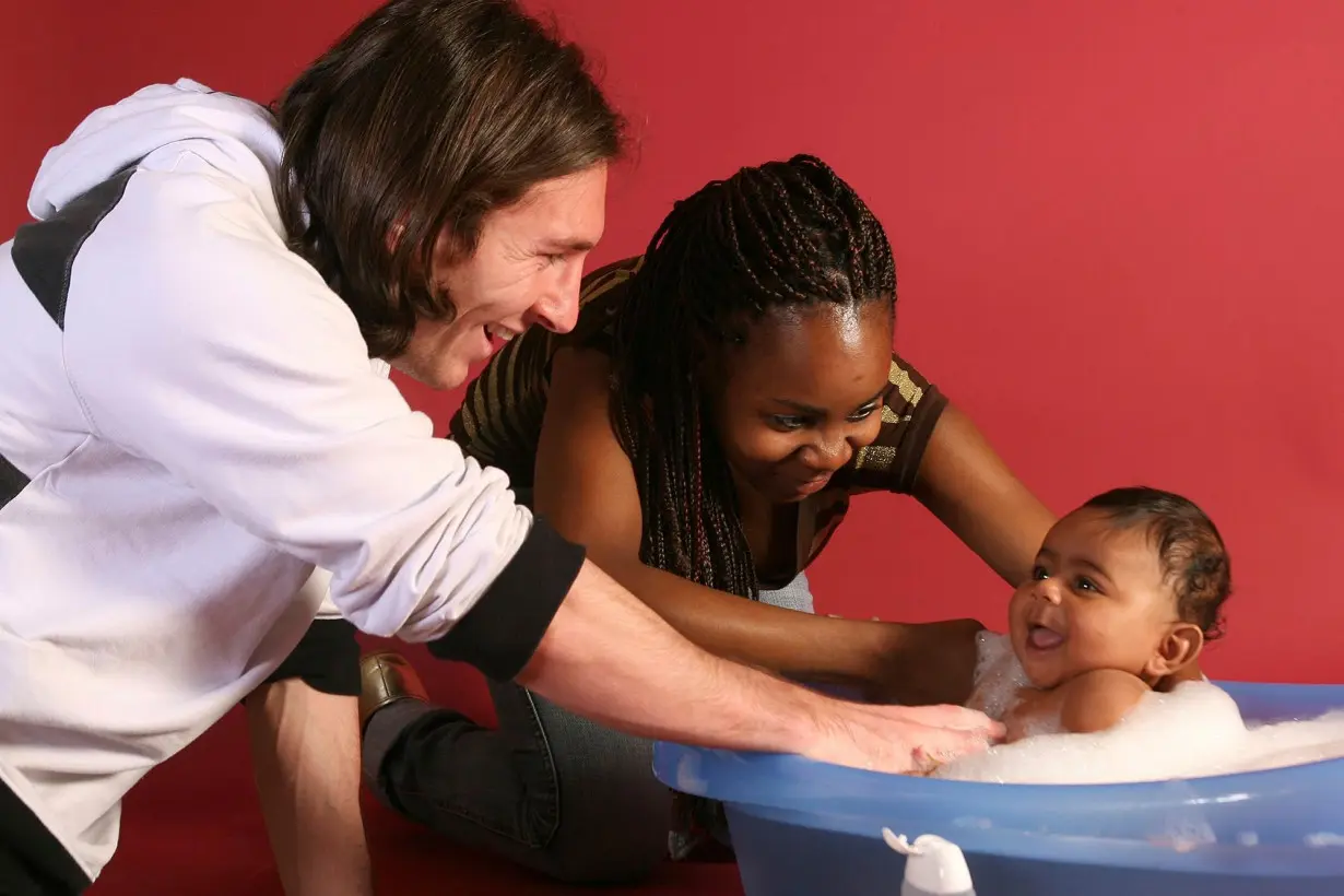 Messi (left) helps to bathe Yamal with his mother, Sheila Ebana.