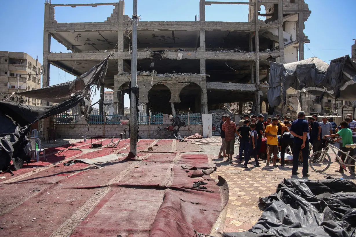 Palestinians gather at the site of an Israeli strike which hit a makeshift prayer hall at Al Shati refugee camp west of Gaza City on July 13, 2024.