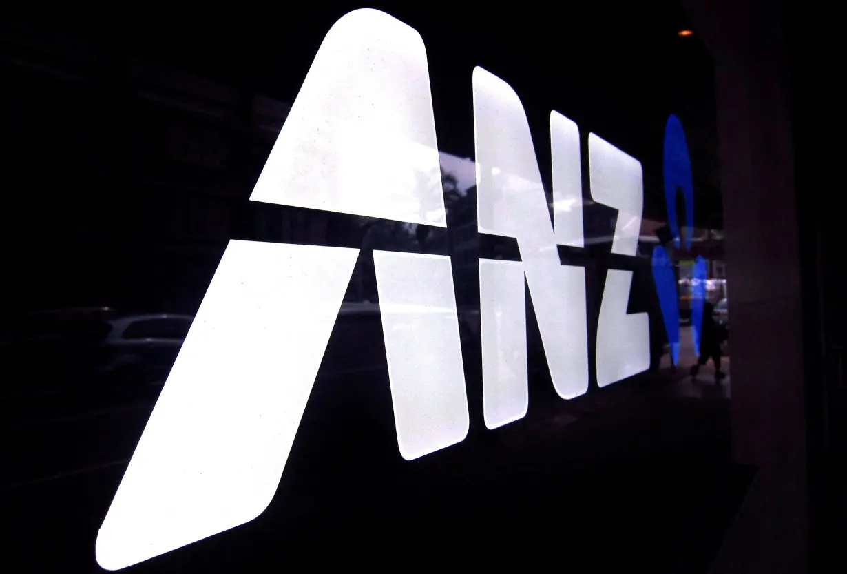 FILE PHOTO: FILE PHOTO: A man walks past a branch of the Australia and New Zealand Banking Group Ltd (ANZ) in Sydney